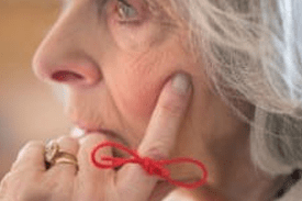 Photo of older woman with string tied around finger